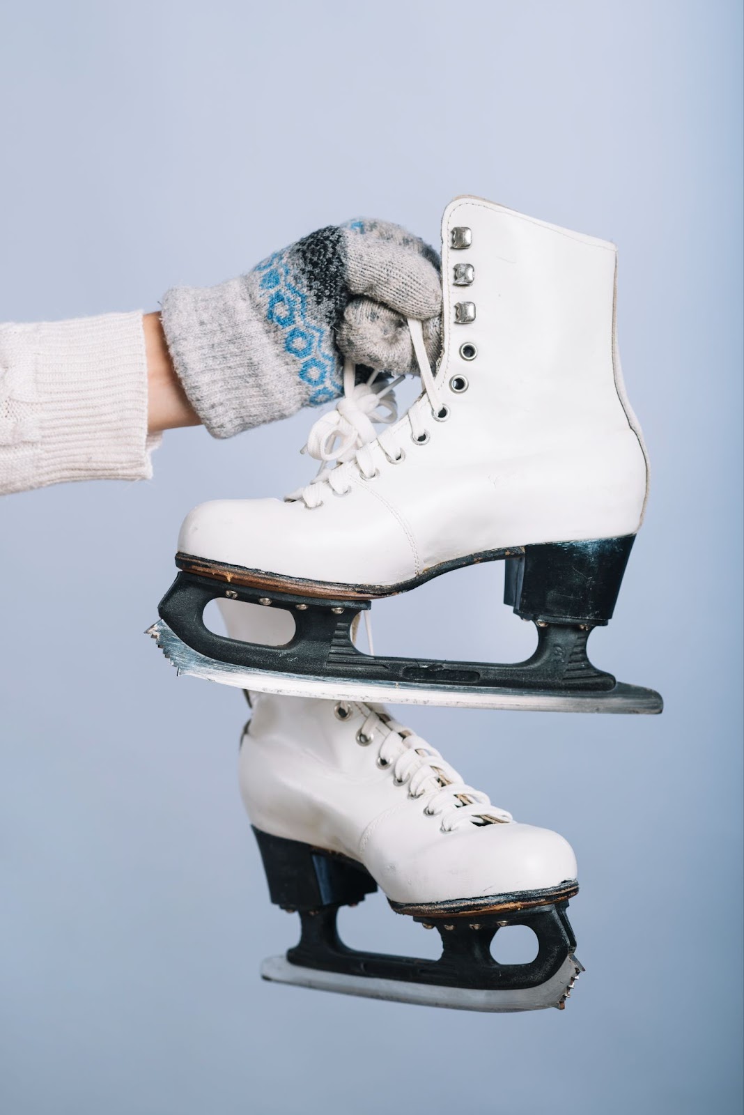 A woman holding a pair of skates