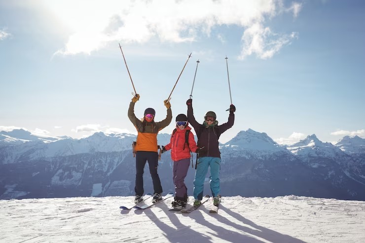 Сelebrating Skiers Standing on Mountain