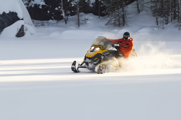 Man riding a snowmobile in a snowy field