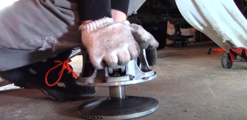 Gloved hand pressing a clutch on the floor