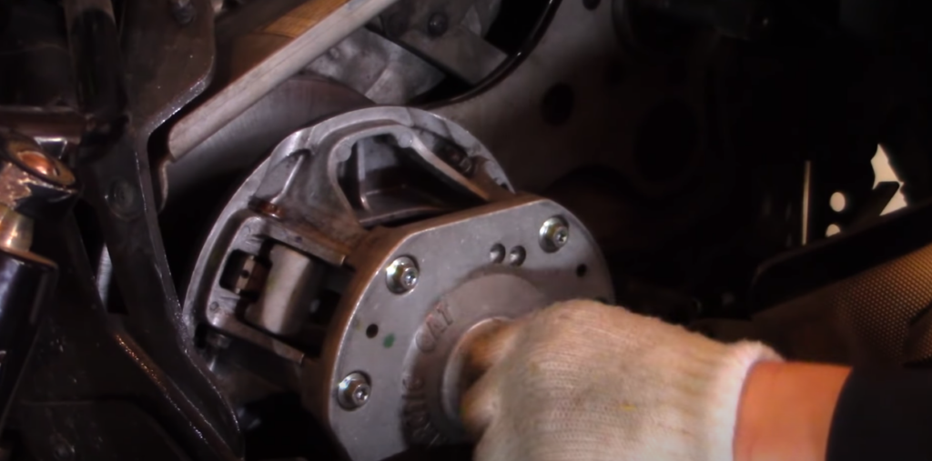 Gloved hand reattaching a clutch to a snowmobile