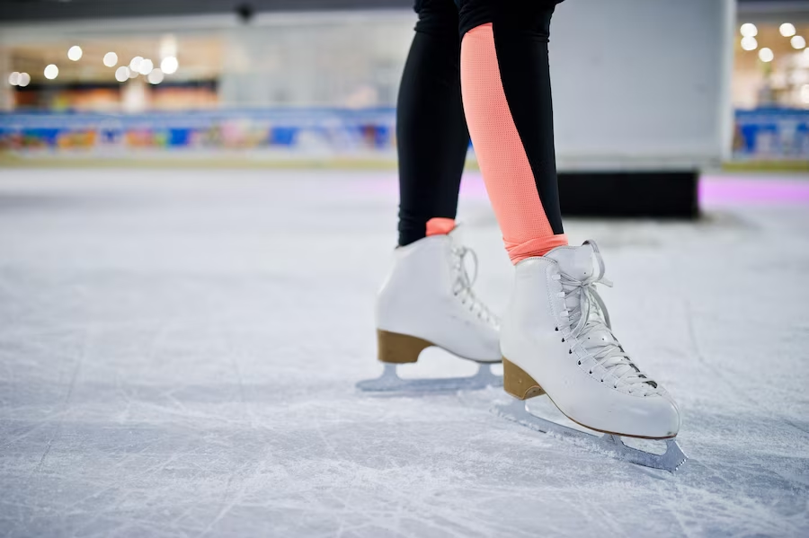 A close-up view of figure skate shoes during ice skating