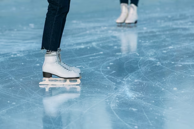 Two individuals ice skating, closed up on their feet