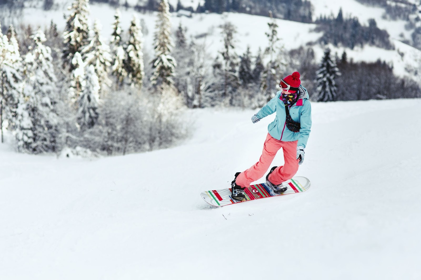 a woman on a snowboard going down a snowy hill