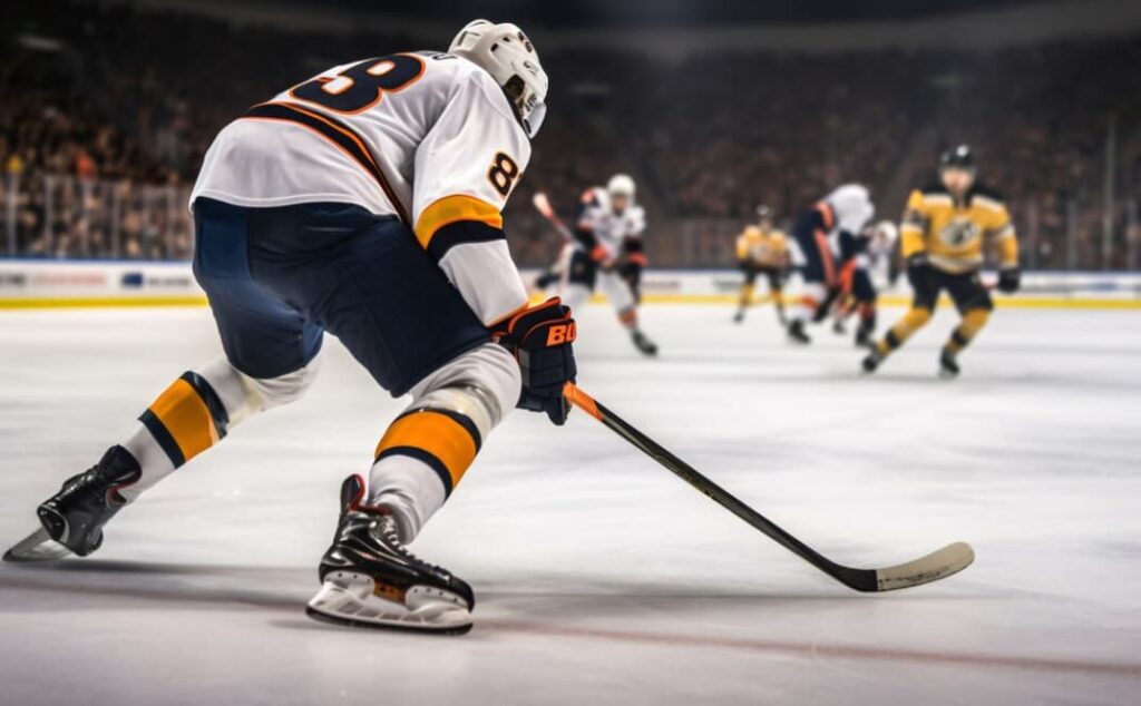 A hockey player in white and blue gear skates swiftly with the puck